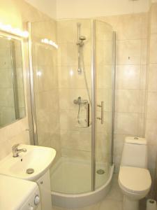 ein Bad mit einer Dusche, einem WC und einem Waschbecken in der Unterkunft Wilson Apartment in Warschau