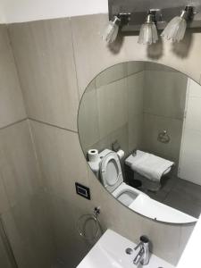a bathroom with a mirror and a toilet and a sink at Espacio Chacabuco in Comodoro Rivadavia