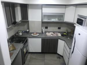 una cocina con armarios blancos y un plato de comida en la barra en Espacio Chacabuco en Comodoro Rivadavia