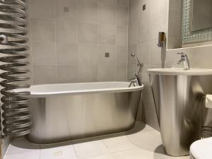 ein Badezimmer mit einer Badewanne und einem Waschbecken in der Unterkunft High View Serviced Apartment in Cardiff