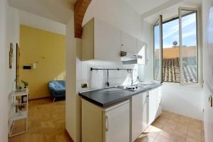 a kitchen with white cabinets and a large window at Take me Rome - Roman Forum Apartments in Rome
