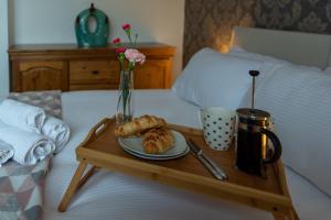 a tray with a plate of pastries on a bed at Trafalgar House in Gorleston-on-Sea