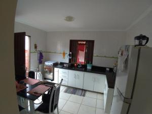 a kitchen with a refrigerator and a table in it at Casa Aconchegante in Paraty +3 photos