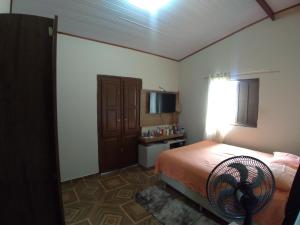 a bedroom with a bed and a television in it at Casa Aconchegante in Paraty