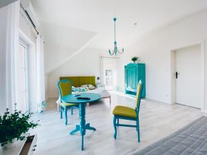 uma sala de estar com uma mesa azul e cadeiras em Piławski Dwór em Piława