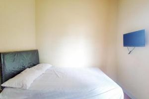 a bedroom with a white bed with a blue wall at Chandra Graha Guesthouse Palu in Palu