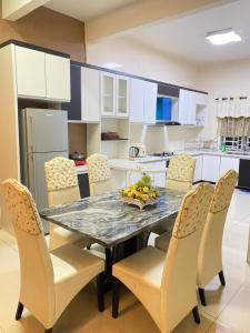 eine Küche mit einem Esstisch und Stühlen in der Unterkunft Azzalea Homes 5 @ Golden Hills Cameron Highlands in Brinchang