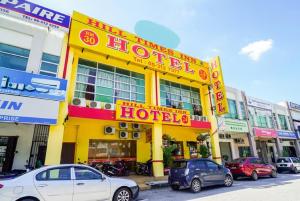 ein gelbes Hotel mit davor geparkt in der Unterkunft Hill Times Inn Hotel in Ipoh