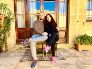 a man and a woman sitting on a chair at Grotto's Paradise B&B in Għarb