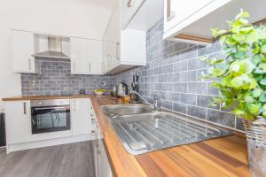 a kitchen with a sink and a stove at Raleigh by Pureserviced in Plymouth