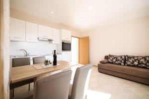 a kitchen and living room with a table and a couch at Apartments Anka with Seaview in Vrsi