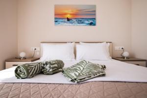 a bed with two pillows on top of it at Apartments Anka with Seaview in Vrsi
