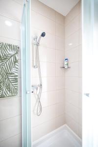 a shower with a glass door in a bathroom at Apartments Anka with Seaview in Vrsi