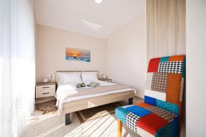a bedroom with a bed and a chair at Apartments Anka with Seaview in Vrsi