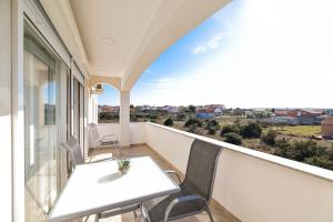 a balcony with a table and chairs and a view at Apartments Anka with Seaview in Vrsi