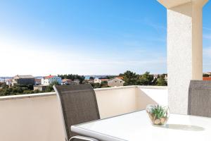 a table and chairs on a balcony with a view at Apartments Anka with Seaview in Vrsi