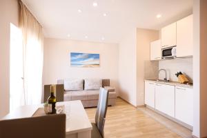 a kitchen and living room with a table and a couch at Apartments Anka with Seaview in Vrsi