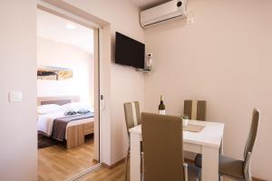 a room with a table and a bed and a room with a window at Apartments Anka with Seaview in Vrsi
