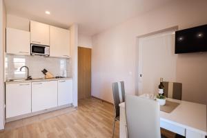 a small kitchen with white cabinets and a sink at Apartments Anka with Seaview in Vrsi