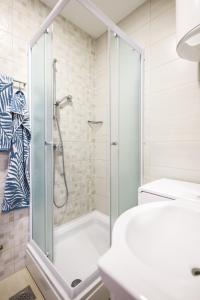 a shower with a glass door in a bathroom at Apartments Anka with Seaview in Vrsi