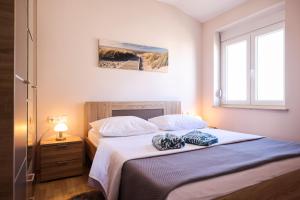a bedroom with two beds and a window at Apartments Anka with Seaview in Vrsi