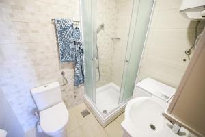 a bathroom with a shower and a toilet and a sink at Apartments Anka with Seaview in Vrsi