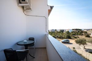 a balcony with a table and a view of a street at Apartments Anka with Seaview in Vrsi