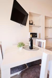 a white table with a bottle of wine and a tv at Apartments Anka with Seaview in Vrsi