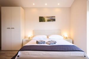 a bedroom with a large bed with two pillows on it at Apartments Anka with Seaview in Vrsi