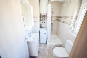 a white bathroom with a sink and a toilet at Apartments Anka with Seaview in Vrsi