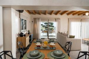 a kitchen and living room with a table and chairs at The Olive Tree Villa Elounda in Elounda