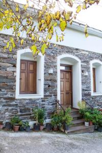 a stone house with two doors and potted plants at Kleopatra's House in Karavostamo