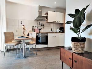 una cocina con armarios blancos y una mesa con una maceta. en Pfefferstübchen Ferienwohnung Schanzenblick, en Brotterode