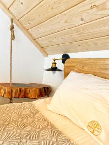 a bedroom with a bed and a wooden ceiling at Dziejba Leśna Apartamenty &Spa in Jaworki