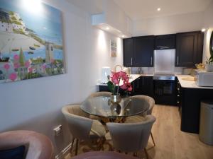 a kitchen with a table with a vase of flowers on it at Beachside Apartment in Carbis Bay