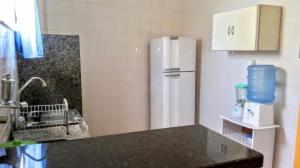 een keuken met een witte koelkast in de kamer bij Apartamento na quadra do mar da Praia do Morro! in Guarapari