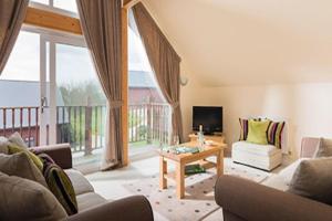un soggiorno con un divano e un tavolo di Swallow Lodge with Hot Tub, dogs welcome sleeps 8, Great resort Facilities a Padstow
