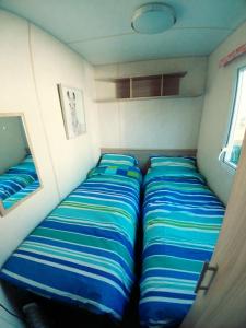 a small bedroom with two beds in it at Len's Getaway Tattershall Lakes in Tattershall