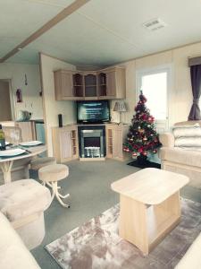 a living room with a christmas tree in it at Len's Getaway Tattershall Lakes in Tattershall