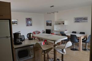 uma cozinha com uma mesa e cadeiras e um micro-ondas em BIARRITZ T3 CENTRE 4/6 PERS,TERRASSE et PARKING em Biarritz