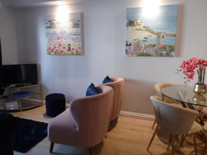 ein Wohnzimmer mit Tisch und Stühlen in der Unterkunft Beachside Apartment in Carbis Bay