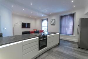 a kitchen with a counter top and a living room at The Balmoral Suite in Plymouth