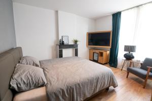 una camera con letto, TV e divano di Brasserie Sint Pieter a Rekem
