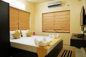 um quarto com uma cama grande e almofadas brancas em Rama Golden Root New town em Calcutá