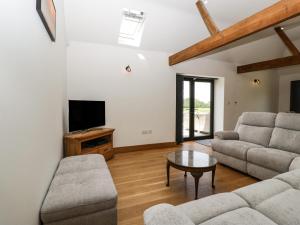 a living room with a couch and a tv at The Old Dairy in Wokingham