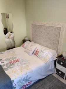 1 dormitorio con 1 cama con edredón blanco en Las Cigüeñas de San Cristóbal, en San Cristóbal de Segovia
