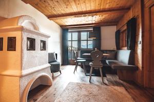 ein Wohnzimmer mit einem Sofa, einem Tisch und Stühlen in der Unterkunft Hotel Chalets Grosslehen in Fieberbrunn