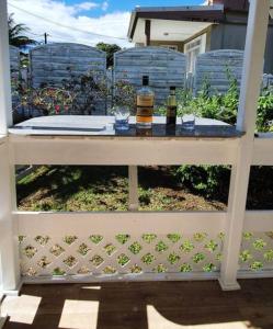 two bottles of wine sitting on top of a fence at Bungalow d'une chambre avec jardin clos et wifi a Fort de France in Fort-de-France