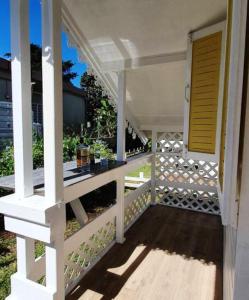 a porch of a white house with a white railing at Bungalow d'une chambre avec jardin clos et wifi a Fort de France in Fort-de-France