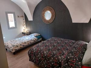 MontaiguL'INATTENDU Vue imprenable,clim,parking avec borne de recharge, ménage inclus的卧室里有一张床，墙上有一面镜子